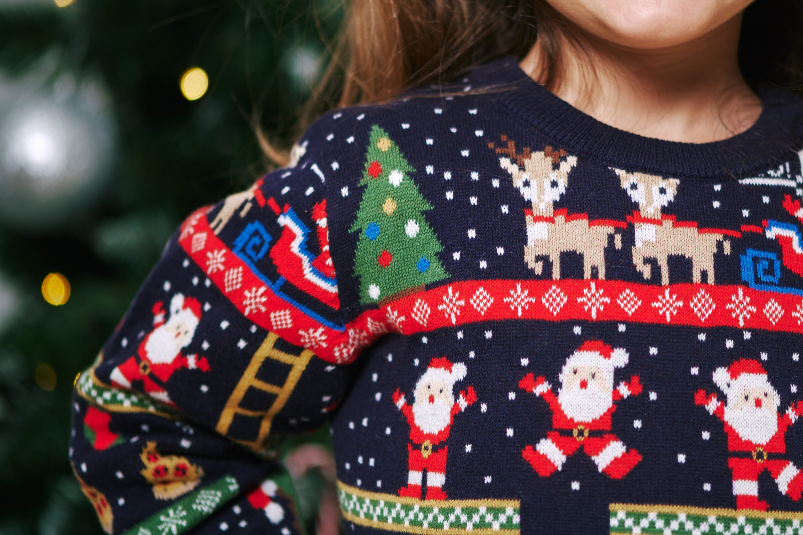 Woman wearing a navy blue Christmas sweater