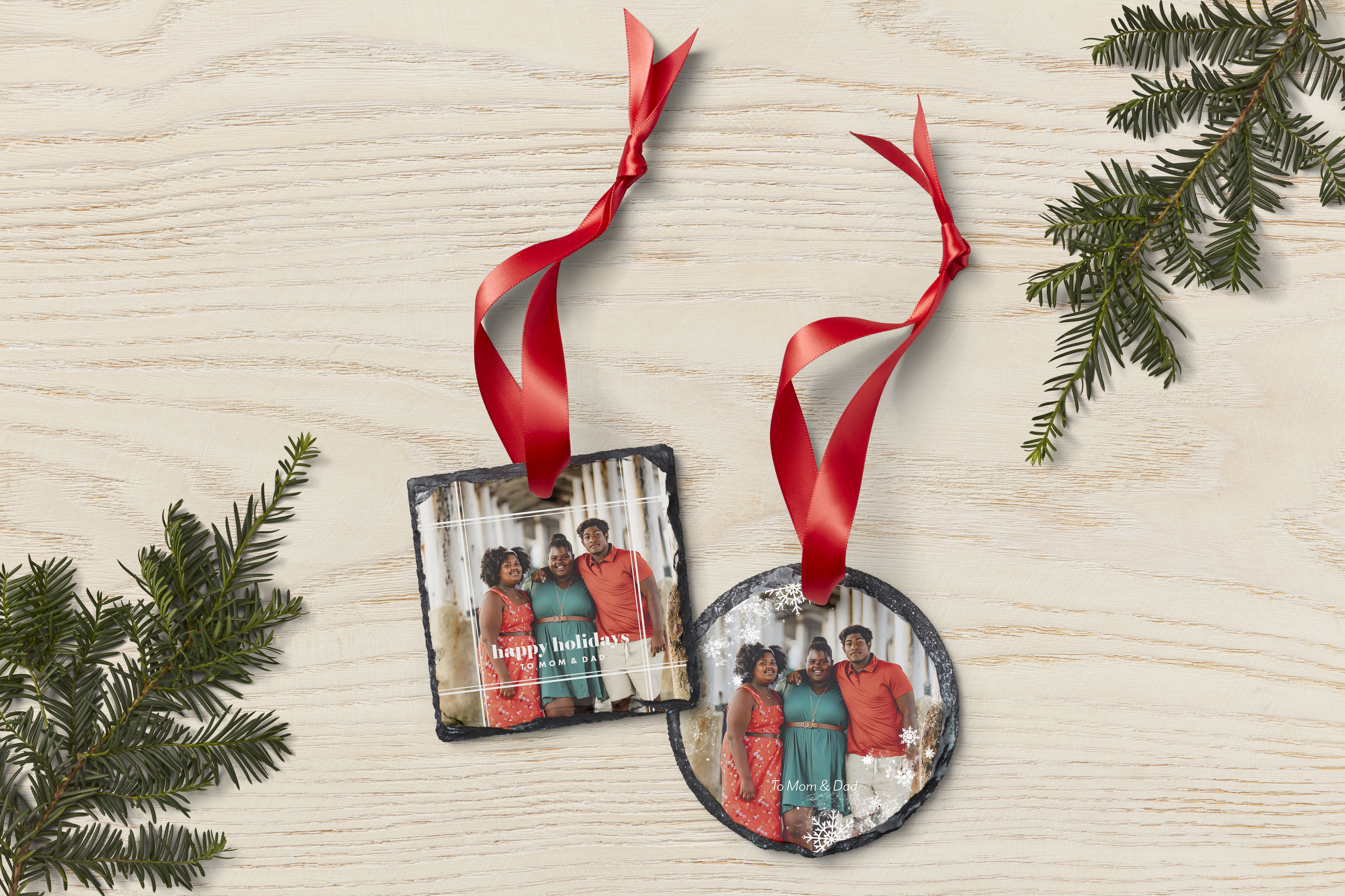 slate ornaments in circle and square shapes with red ribbon attached to the top