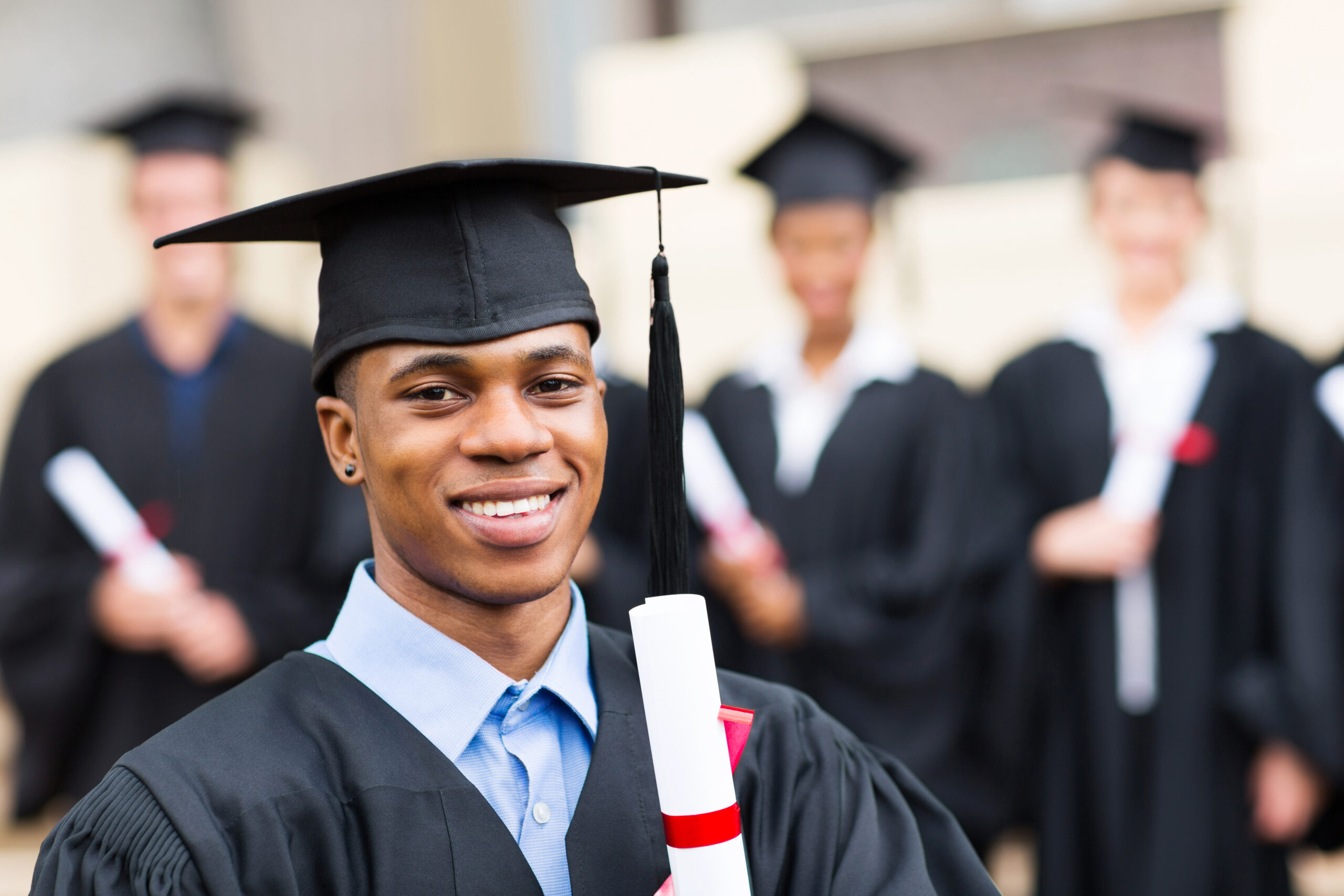 young man wearing graduation cap and gown