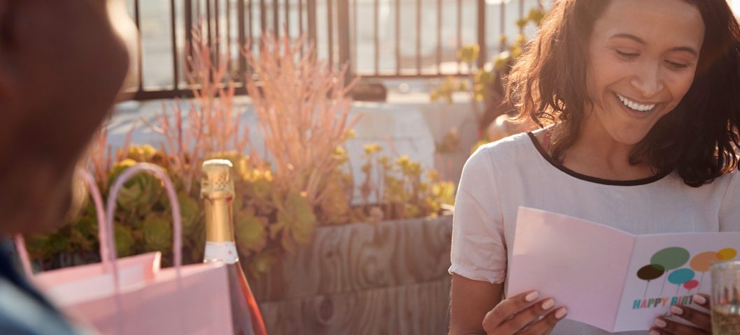 Woman smiling while reading a birthday card