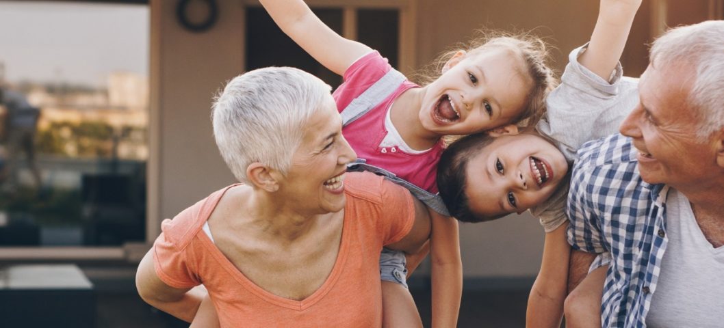 carefree grandparents piggybacking their joyful grandkids