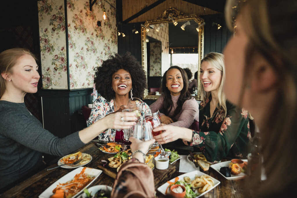 women cheersing each other with drinks