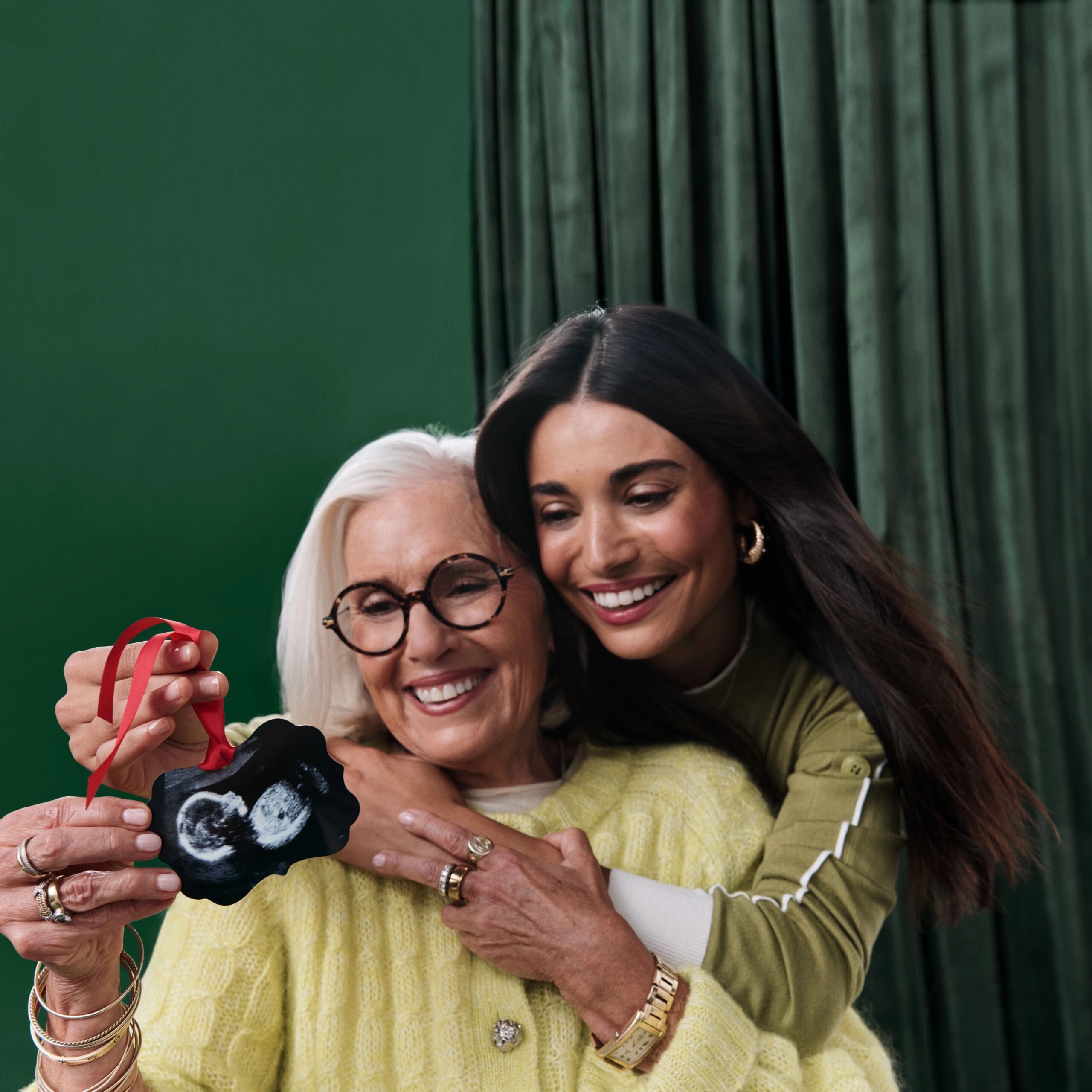 two women holding a metal christmas ornament