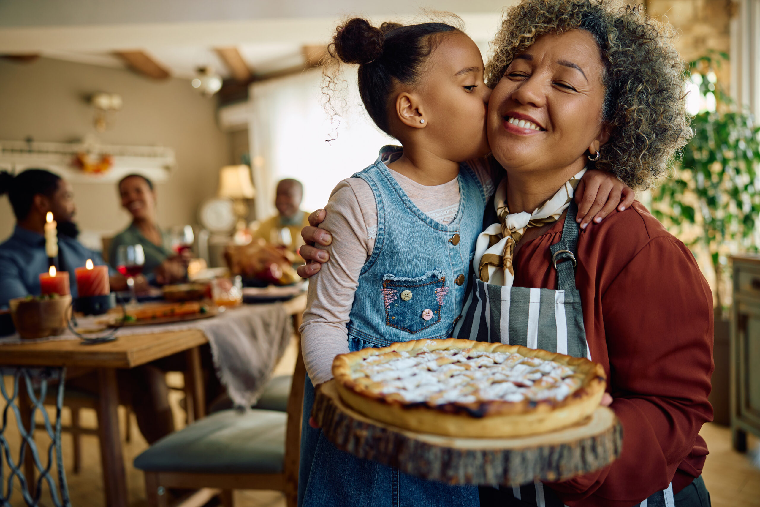 grandmother and granddaughter embracing holding a pie